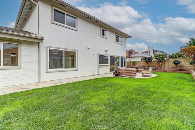 back of property with a patio, fence, an outdoor living space, a lawn, and stucco siding