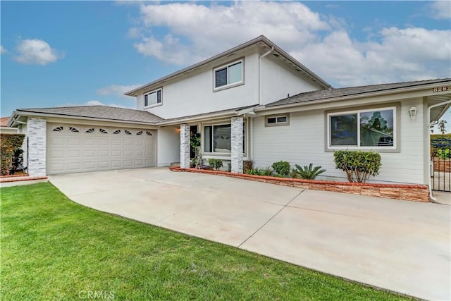 traditional-style home with driveway, a front lawn, and an attached garage