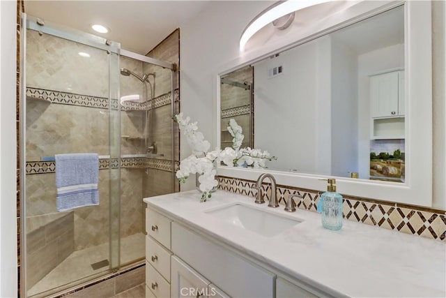 full bath with a stall shower, visible vents, and vanity