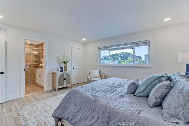 bedroom featuring recessed lighting, connected bathroom, baseboards, and wood finished floors