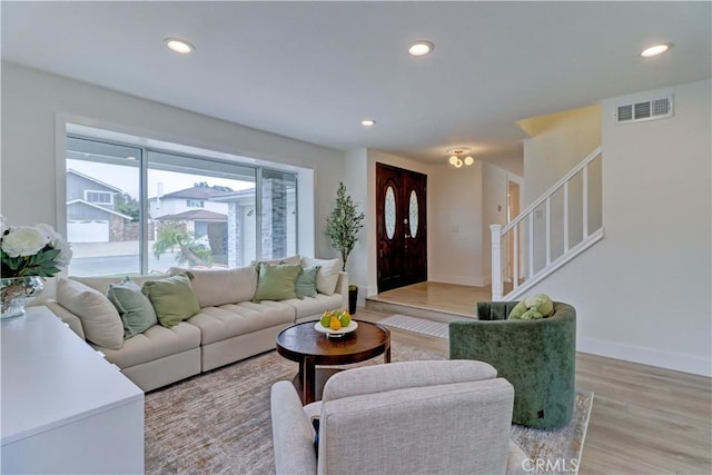 living area with stairs, light wood-style floors, visible vents, and recessed lighting