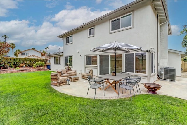 rear view of house with central AC, a lawn, stucco siding, a patio area, and an outdoor living space with a fire pit