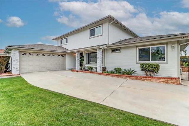 traditional-style home with concrete driveway, an attached garage, and a front yard