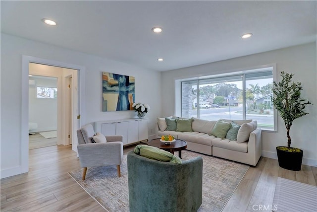 living room with baseboards, radiator heating unit, recessed lighting, and light wood-style floors