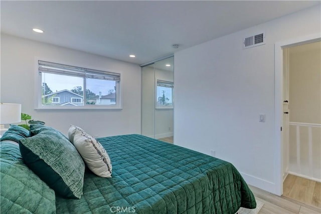 bedroom featuring visible vents, baseboards, light wood-style flooring, and recessed lighting