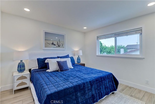 bedroom featuring baseboards, wood finished floors, and recessed lighting