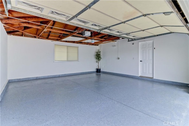 garage with a garage door opener and baseboards