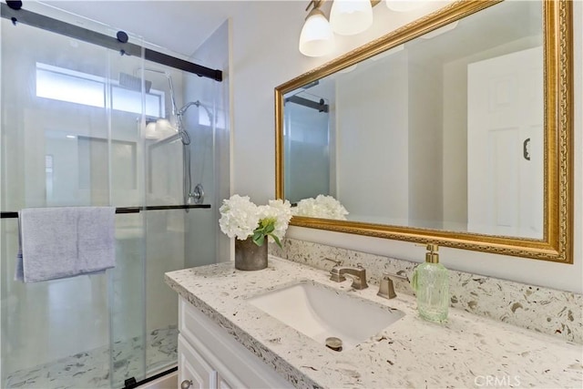 full bathroom with a shower stall and vanity