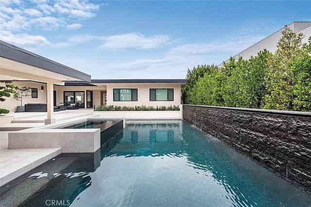 pool with a patio and an in ground hot tub