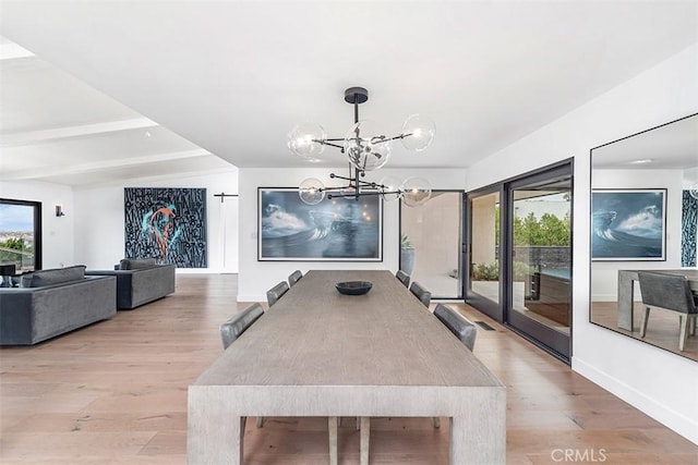 dining space featuring a chandelier, light wood-type flooring, beam ceiling, and baseboards