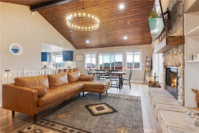 living room featuring a healthy amount of sunlight, an inviting chandelier, wood ceiling, and light wood finished floors