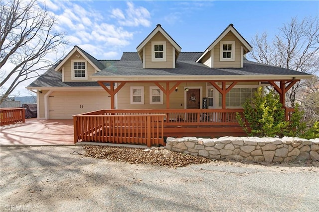 view of front of property featuring a shingled roof, covered porch, an attached garage, and concrete driveway