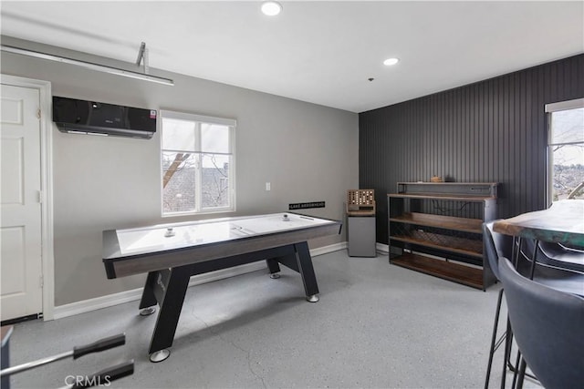 recreation room featuring recessed lighting, a wall unit AC, and baseboards