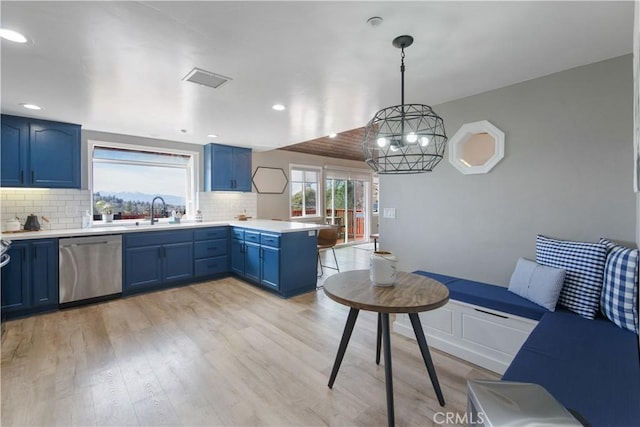 kitchen with light wood finished floors, decorative backsplash, dishwasher, blue cabinets, and a peninsula