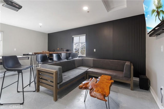 living area with concrete flooring, recessed lighting, and baseboards