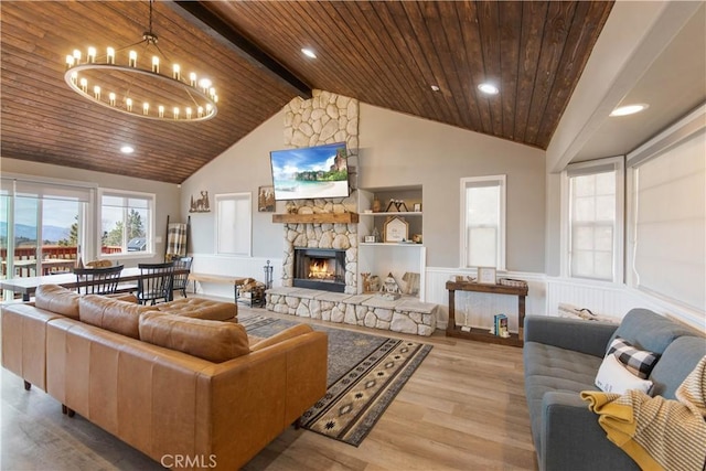 living area with a stone fireplace, wooden ceiling, wood finished floors, and beam ceiling