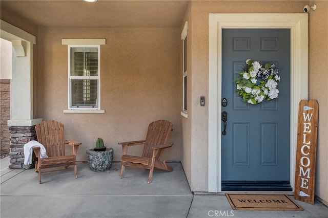 property entrance featuring stone siding and stucco siding