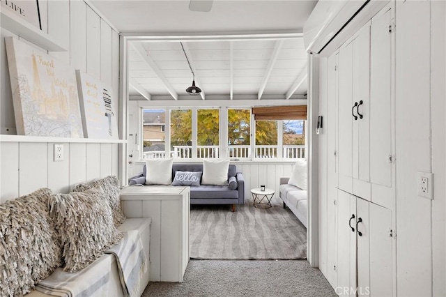 sunroom / solarium featuring beamed ceiling