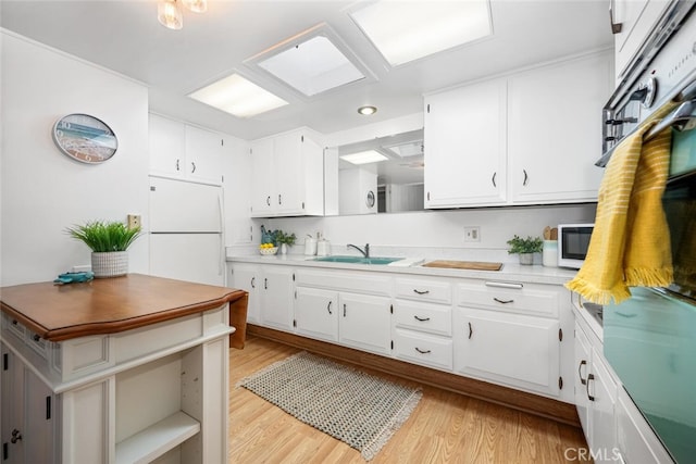 kitchen featuring open shelves, white appliances, a sink, and light wood-style floors