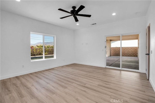 empty room with light wood-type flooring, baseboards, and recessed lighting