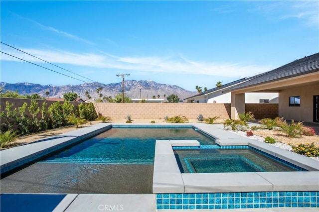 view of pool featuring an in ground hot tub, a fenced backyard, a mountain view, and a fenced in pool