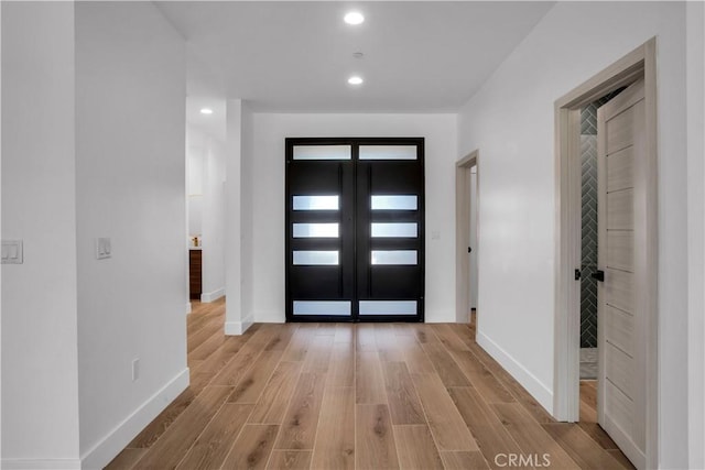 entrance foyer with light wood-style floors, recessed lighting, french doors, and baseboards