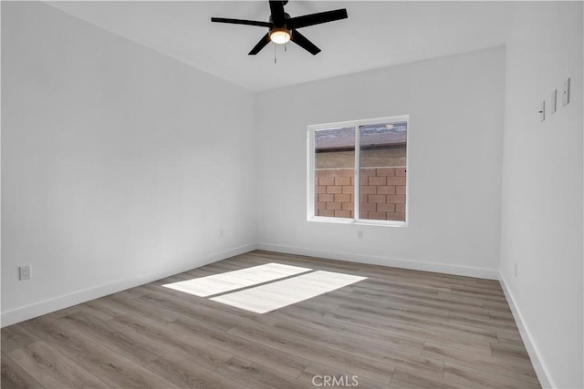 unfurnished room featuring a ceiling fan, baseboards, and wood finished floors