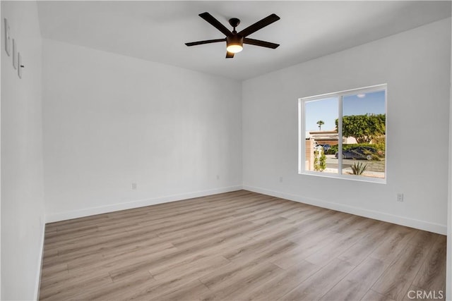 unfurnished room featuring a ceiling fan, light wood-style flooring, and baseboards