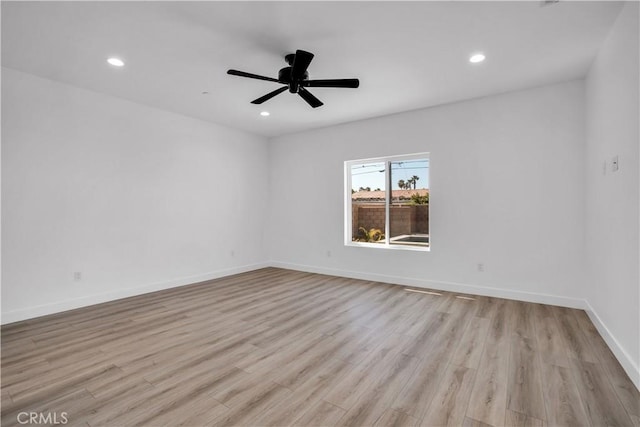 empty room featuring baseboards, wood finished floors, and recessed lighting