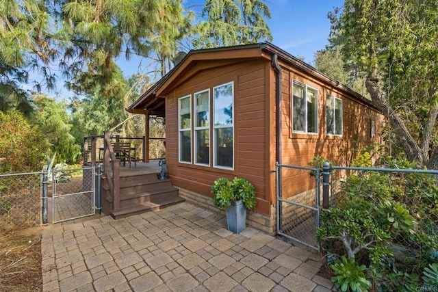 view of property exterior with a gate, fence, and a deck