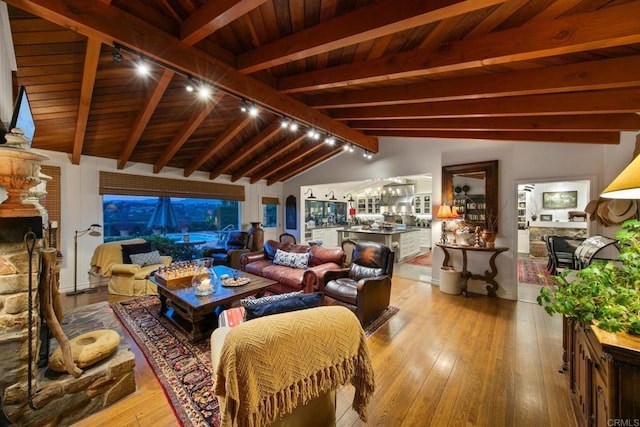 living room with wood ceiling, wood-type flooring, a fireplace, and lofted ceiling with beams