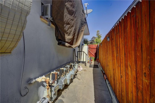 view of side of home featuring fence and stucco siding