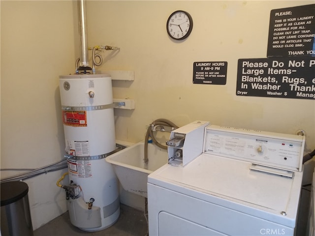 clothes washing area with laundry area, a sink, and strapped water heater