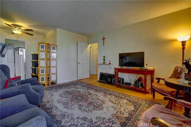 living area with a ceiling fan and wood finished floors