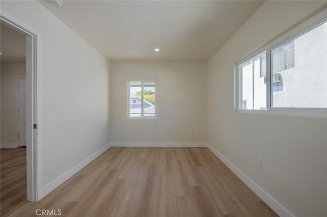 empty room with recessed lighting, light wood-type flooring, and baseboards