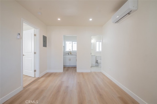 unfurnished room with light wood-type flooring, recessed lighting, baseboards, and a wall mounted AC