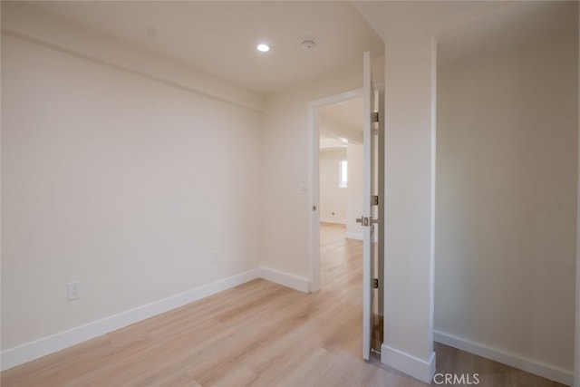 unfurnished room with light wood finished floors, baseboards, and recessed lighting