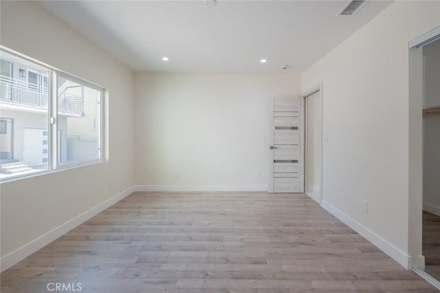 spare room with light wood-type flooring, visible vents, baseboards, and recessed lighting