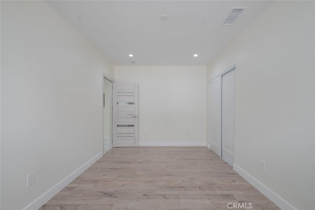 spare room featuring recessed lighting, visible vents, light wood-style flooring, and baseboards