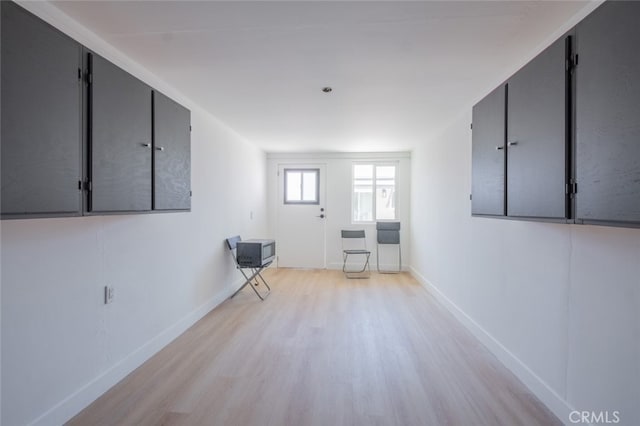 spare room featuring light wood-type flooring and baseboards