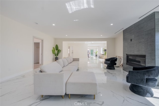 living area with marble finish floor, baseboards, a tiled fireplace, and recessed lighting