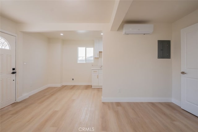 foyer entrance featuring light wood finished floors, a wall mounted air conditioner, electric panel, and baseboards