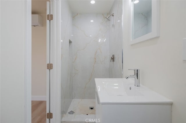 full bathroom with vanity, a marble finish shower, and wood finished floors