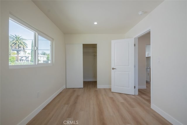 unfurnished bedroom with light wood-style floors, a closet, recessed lighting, and baseboards