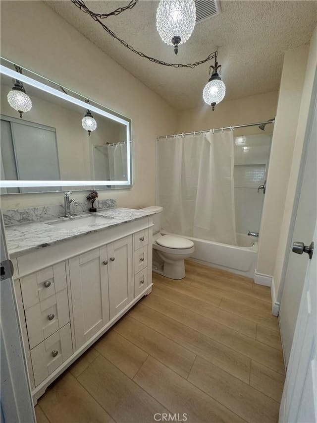 full bathroom featuring visible vents, toilet, wood finished floors, shower / bath combo with shower curtain, and vanity