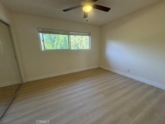 unfurnished bedroom with a ceiling fan, a closet, baseboards, and light wood finished floors