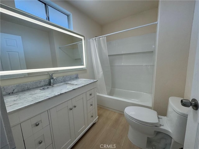 full bathroom with vanity, shower / bath combo with shower curtain, wood finished floors, and toilet