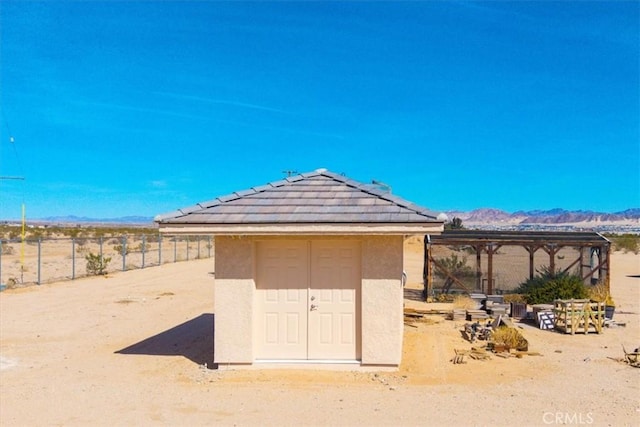 view of shed featuring fence and a mountain view