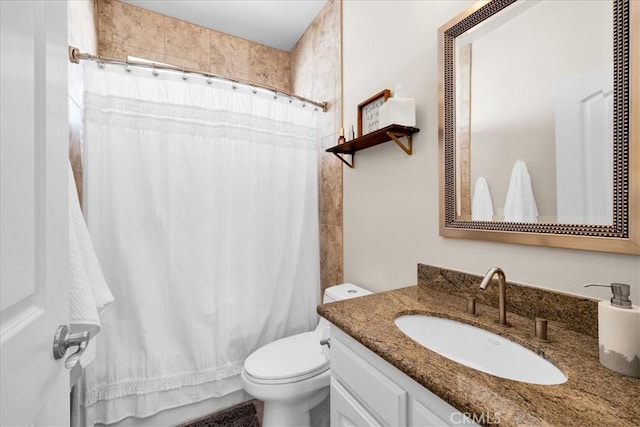 bathroom featuring toilet, a shower with shower curtain, and vanity