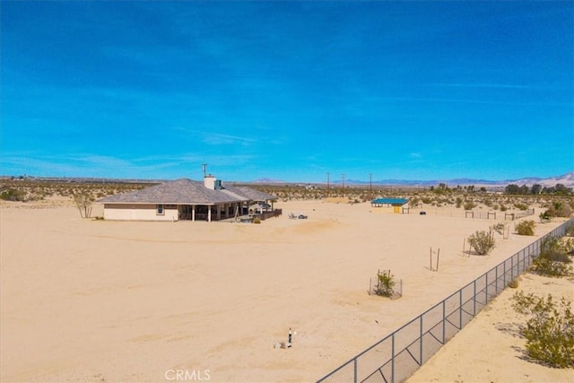 view of yard featuring view of desert and fence